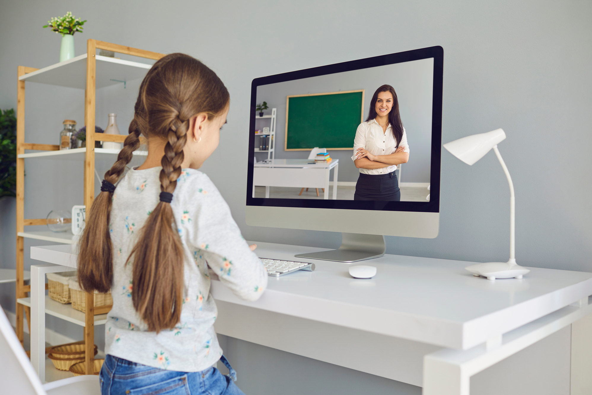 Distance Learning Education. a Little Girl Listens to a Teacher Video Lecture Online in a Laptop at the Table at Home.